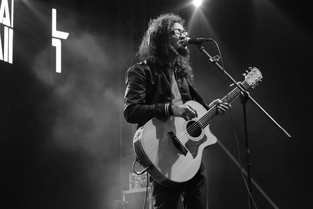 A guitarist at the microphone in stage smoke, in black and white