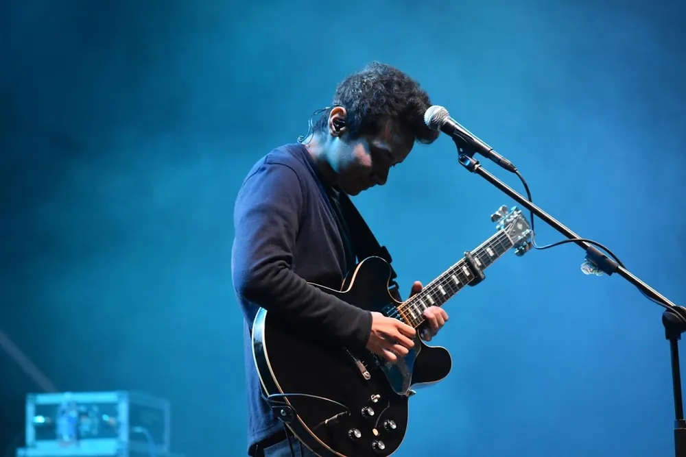 A guitarist at the microphone in blue light